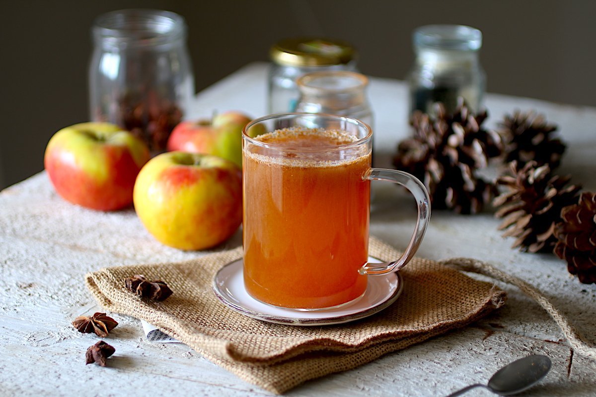 Succo di mele in una tazza trasparente al centro di un tavolo